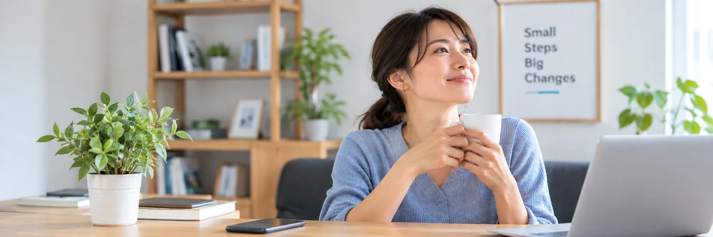 コーヒーを手に一息つきながら、次に見直す仕事を考えている個人事業主のデスク